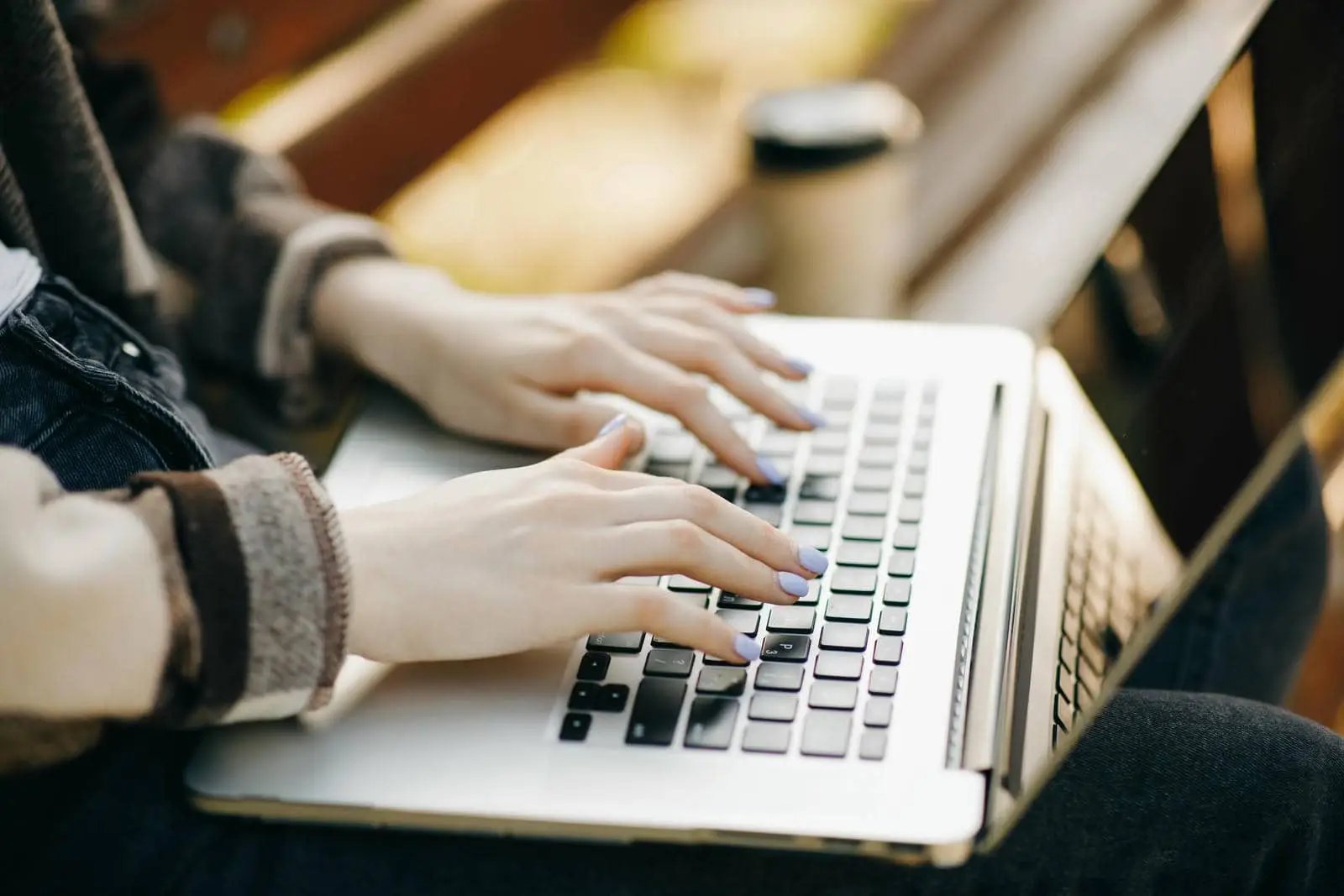 Close-up of a person typing on a laptop outdoors, highlighting the effectiveness of the best email marketing services for restaurants and hotels