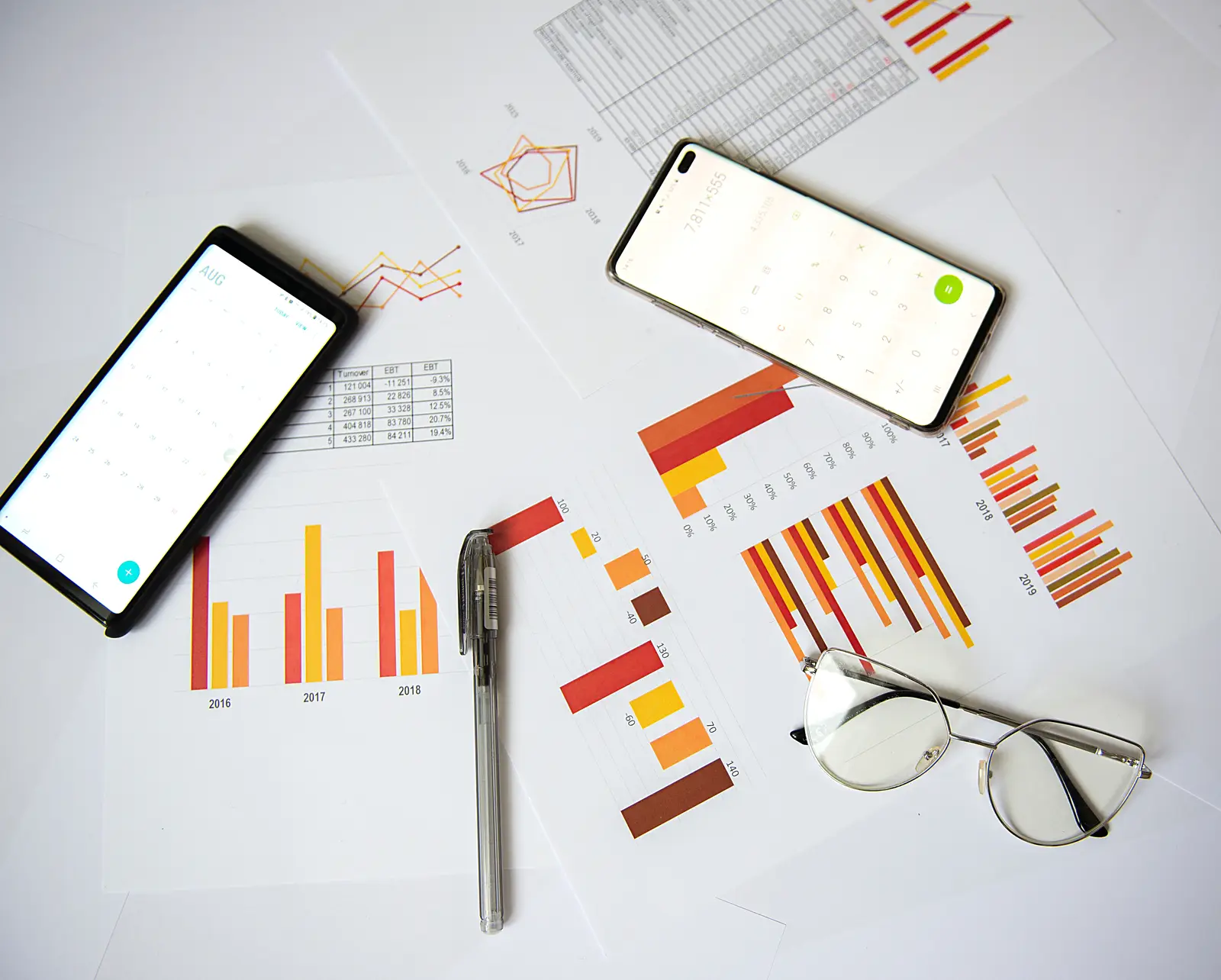 Charts and smartphones on a table, representing a search engine marketing strategy.