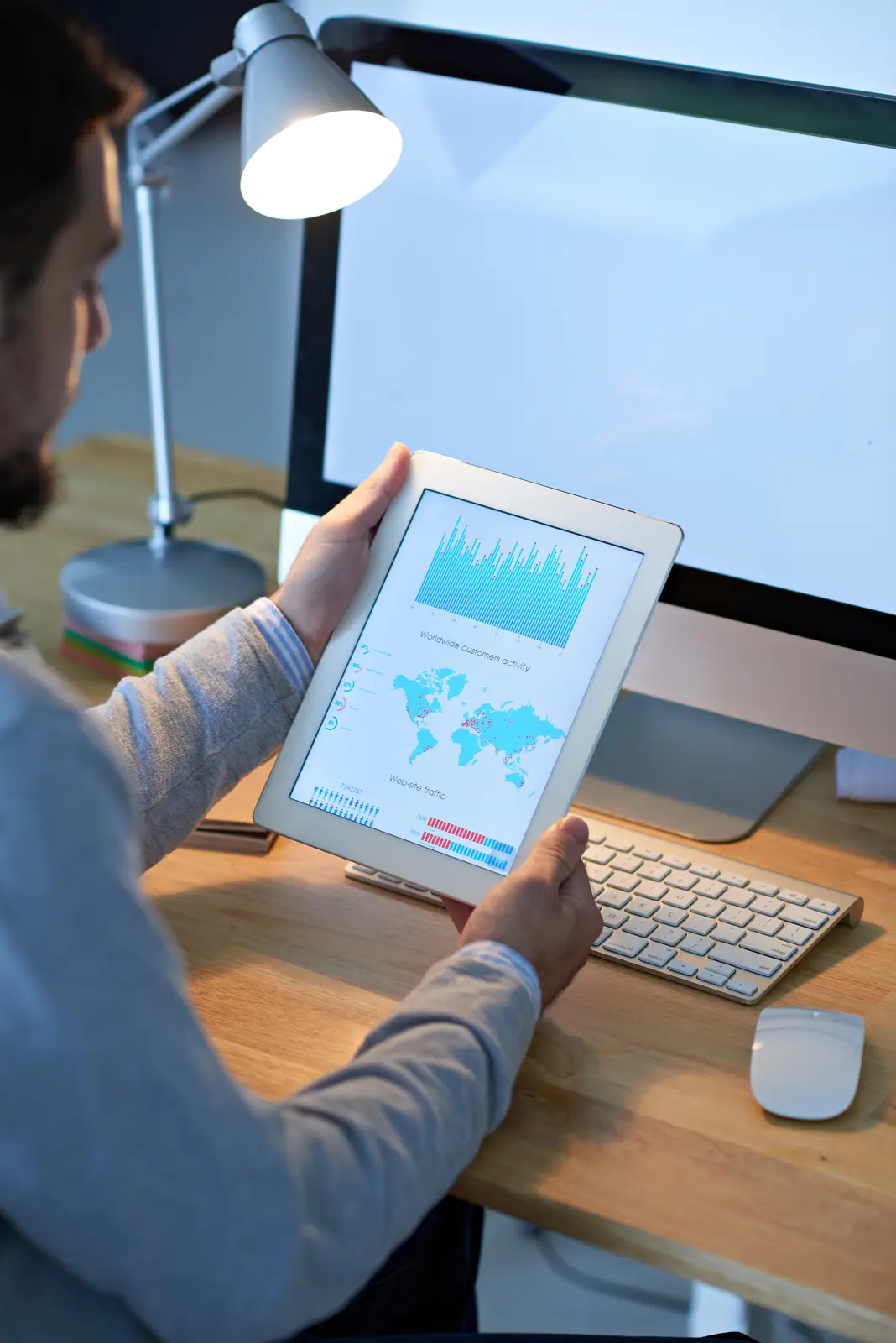 Person analyzing web traffic data on a tablet, showing the impact of small business website design services.