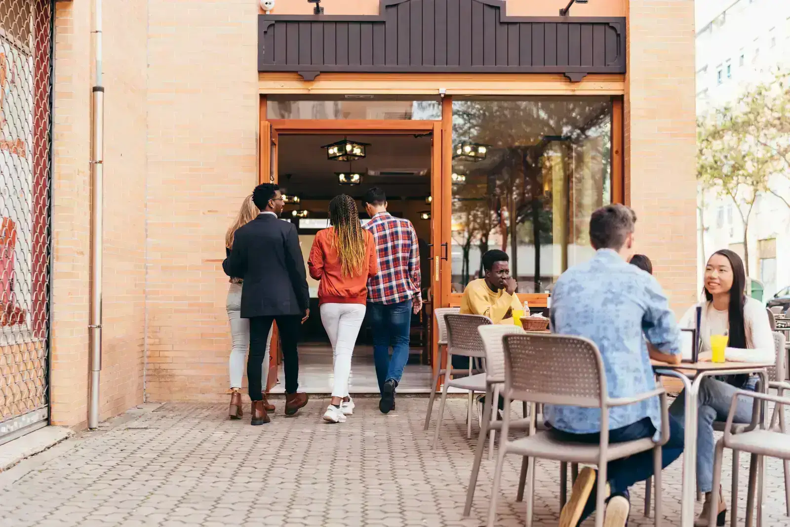 A group of people entering a restaurant, symbolizing online marketing strategies for small business.