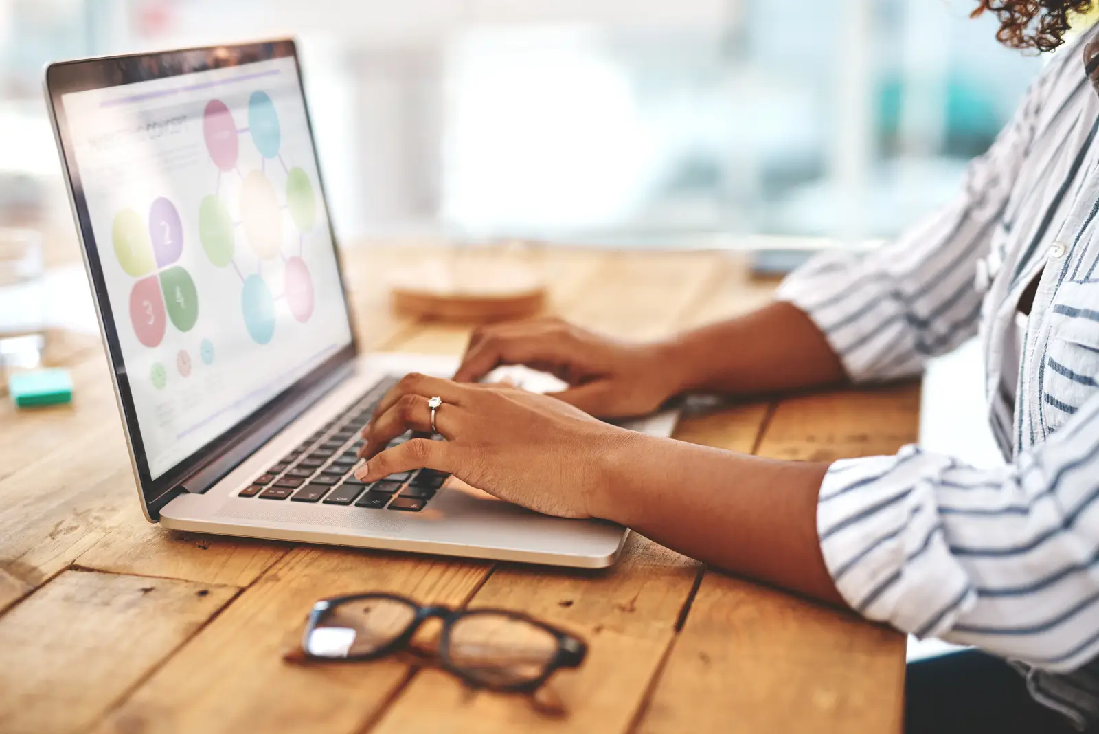 A woman working on a laptop with a web design project, highlighting why responsive web design is important.