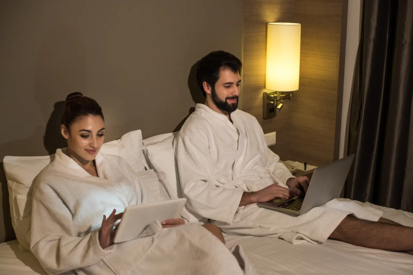 Couple in bathrobes using devices, showcasing the comfort of running SEM campaigns.